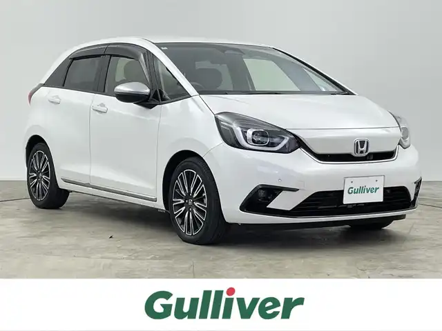 ホンダ フィット e:HEVリュクス 千葉県 2022(令4)年 2.1万km プラチナホワイトパール 禁煙車/ホンダセンシング/・誤発進抑制機能（前方・後方）/・近距離衝突軽減ブレーキ（前方・後方）/・路外逸脱抑制機能/・歩行者事故低減ステアリング/・車線維持支援システム/・渋滞追従機能付きアダプティブクルーズコントロール/・先行車発進お知らせ機能/・標識認識機能/・オートハイビーム/純正9インチナビ/・型式：VXU-225FTi/・CD/DVD/フルセグTV/Bluetooth/バックカメラ/シートヒーター/ステアリングヒーター/ワイヤレス充電/コーナーセンサー/ビルトインＥＴＣ/キルティングパーフォレーション本革シート/本革巻ステアリングホイール/LEDオートライト/LEDフォグランプ/LUXE専用エクステリア（プラチナ調クロームメッキ・フロントバンパーモールディング）/LUXE専用エクステリア（プラチナ調クロームメッキ・ドアロアーガーニッシュ）/LUXE専用エクステリア（プラチナ調クロームメッキ・テールゲートロアーガーニッシュ）/LUXE専用デザイン16インチアルミホイール/純正フロアマット/電動パーキング/オートブレーキホールド/スペアキー1本