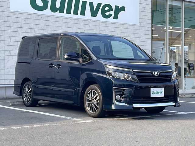 トヨタ ヴォクシー ZS 静岡県 2014(平26)年 4.1万km ブラッキッシュアゲハガラスフレーク 純正ナビ/地デジTV/純正CD/DVD/Bluetooth/バックカメラ/両側パワースライドドア/フリップダウンリアモニター/LEDヘッドライト/アイドリングストップ/純正16インチAW/オートライト/ビルトインETC