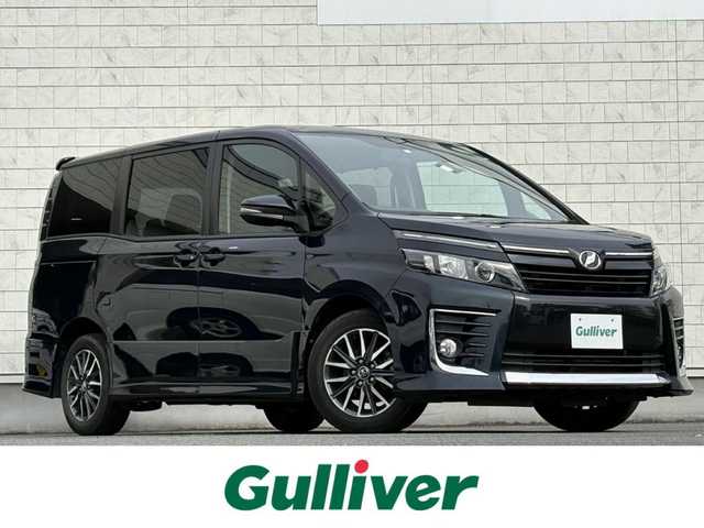 トヨタ ヴォクシー ZS 岩手県 2014(平26)年 4.1万km ブラッキッシュアゲハガラスフレーク 禁煙車/フリップダウンモニター/両側パワースライドドア/2列目サンシェード/純正ナビ/→フルセグTV/Bluetooth/CD/DVD/FM/AM/ステアリングスイッチ/オートライト/LEDヘッドライト/フォグライト/横滑り防止装置/〇プッシュスタート/〇電動格納ミラー/〇ウィンカーミラー/〇全席オートパワーウィンドウ/〇フロアマット/〇シガーソケット/〇スマートキー/ビルトインETC