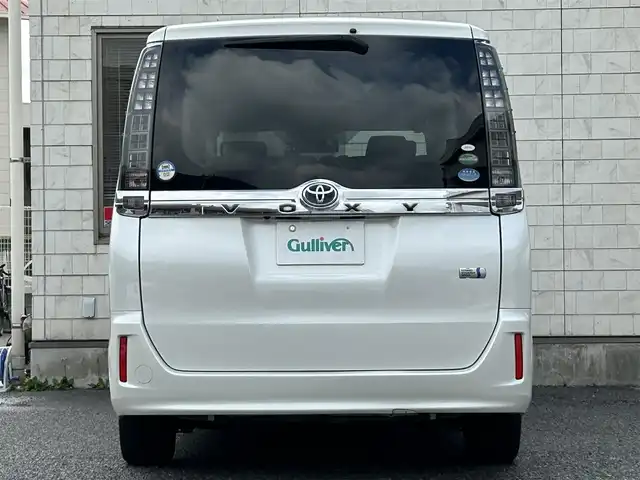 トヨタ ヴォクシー ハイブリッド X 福岡県 2015(平27)年 11.7万km ホワイトパールクリスタルシャイン 後部座席11インチフリップダウンモニター【V11T-R62C】/純正9インチメモリナビ【NSZT-Y64T】/　（AM/FM/CD/DVD/Bluetooth/フルセグTV）/バックカメラ/横滑り防止装置/オートライト/車両接近警報装置/両側パワースライドドア/社外15インチアルミホイール(サーキュラー)/ビルトインETC/コムテック製前後ドライブレコーダー【DC-DR652】/3列シート/社外フロアマット(YMT)/後部座敷サンシェード/電格ウインカーミラー/ドアバイザー/ステアリングスイッチ/電源ソケット×1/ISOFIX/スペアキー×1/保証書/取扱説明書/ナビ取扱説明書