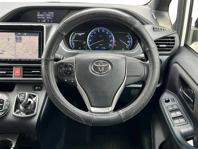 トヨタ ヴォクシー ハイブリッド X 福岡県 2015(平27)年 11.7万km ホワイトパールクリスタルシャイン 後部座席11インチフリップダウンモニター【V11T-R62C】/純正9インチメモリナビ【NSZT-Y64T】/　（AM/FM/CD/DVD/Bluetooth/フルセグTV）/バックカメラ/横滑り防止装置/オートライト/車両接近警報装置/両側パワースライドドア/社外15インチアルミホイール(サーキュラー)/ビルトインETC/コムテック製前後ドライブレコーダー【DC-DR652】/3列シート/社外フロアマット(YMT)/後部座敷サンシェード/電格ウインカーミラー/ドアバイザー/ステアリングスイッチ/電源ソケット×1/ISOFIX/スペアキー×1/保証書/取扱説明書/ナビ取扱説明書