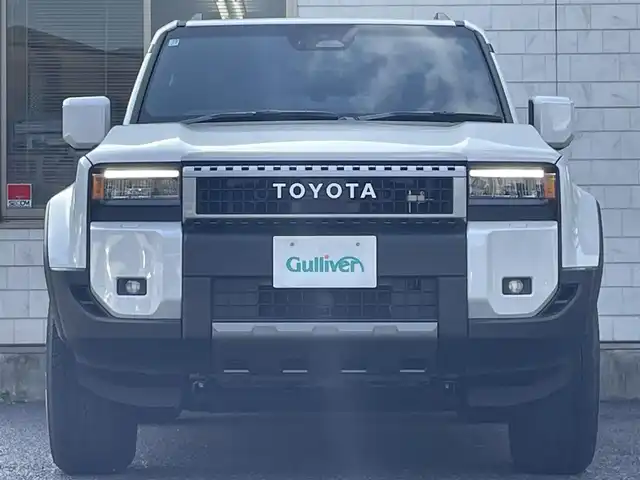 トヨタ ランドクルーザー ２５０ VX 福岡県 2025(令7)年 0.1千km プラチナホワイトパールマイカ ワンオーナー/ムーンルーフ/デジタルインナーミラー/12.3インチディスプレイオーディオ/　(AM/FM/CD/DVD/Bluetooth/Miracast/フルセグTV/ナビキット)/パノラミックビューモニター/バックカメラ/トヨタセーフティセンス/・プリクラッシュセーフティ/・レーンディパーチャーアラート/・レーダークルーズコントロール/・ブラインドスポットモニター/・プロアクティブドライビングアシスト/・リヤクロストラフィックアラート/・後方車両接近告知/・リヤカメラディテクション/・安心降車アシスト/・周辺車両接近時サポート/オートマッチックハイビーム/ロードサインアシスト/クリアランスソナー/横滑り防止/純正18インチアルミホイール/パワーバックドア/黒ルーフレール/ヘッドライトウォッシャー/パワーシート(D)/シートヒーター/ベンチレーション(D/N)/純正前後ドライブレコーダー/黒レザーシート/ステアリングヒーター/革巻きステアリング/パワーシート(D/N)/ビルトインETC2.0/社外フロアマット/USBタイプCポート/スペアキー×1/保証書/取扱説明書/ナビ取扱説明書