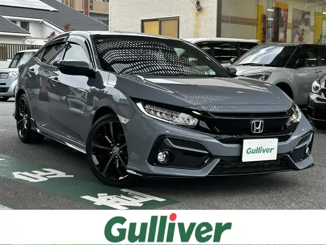 ホンダ シビック ハッチバック 福岡県 2020(令2)年 1.9万km ソニックグレーパール 純正ディーラーナビ/・Bluetooth/・フルセグTV/・CD/DVD/・バックカメラ/・ラジオ/サンルーフ/レーダークルーズコントロール/パドルシフト/ステアリングリモコン/プリクラッシュセーフティー/レーンアシストコントロール/横滑り防止システム/アイドリングストップ/ブレーキホールド/シートヒーター/ビルトインETC/革シート/純正アルミホイール/純正フロアマット/ウィンカーミラー/ドアバイザー/プッシュスタート/取扱説明書/保証書/スペアキー×１