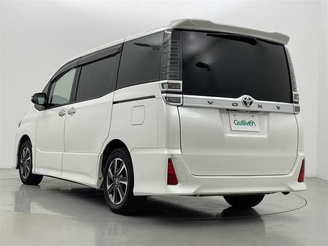 トヨタ ヴォクシー ZS 煌 熊本県 2018(平30)年 5.2万km ホワイトパールクリスタルシャイン 純正9インチナビ（ＣＤ・ＤＶＤ・フルセグ・ＳＤ・ＢＴ）/USB入力端子/純正12インチフリップダウンモニター　/バックカメラ　/ビルトインＥＴＣ　/両側パワースライドドア　/前後クリアランスソナー　/トヨタセーフティーセンス/・衝突軽減ブレーキ/・レーンキープアシスト/・クルーズコントロール/・オートマチックハイビーム/横滑り防止/アイドリングストップ/純正フロアマット/純正１６インチAW/オートライト/LEDヘッドライト/フォグライト/スマートキー/プッシュスタート/スペアキー１本/取扱説明書