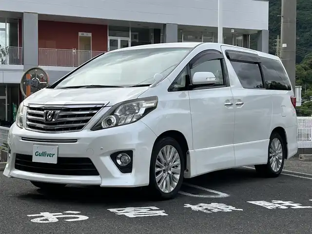 トヨタ アルファード 240S 長崎県 2012(平24)年 9.5万km ホワイトパールクリスタルシャイン 純正アルファード専用ナビ(FM/AM/CD/DVD/BT/TV)/プッシュスタート/スマートキー/ビルトインETC/純正フロアマット/純正アルミホイール/MTモード付AT/レザーシート/2列目オットマン/3列シート/後席用モニター/両側イージークローザードア/バックカメラ/オートライト/ABS/横滑り防止装置(VSC)/盗難防止装置/取扱説明書/記録簿/保証書