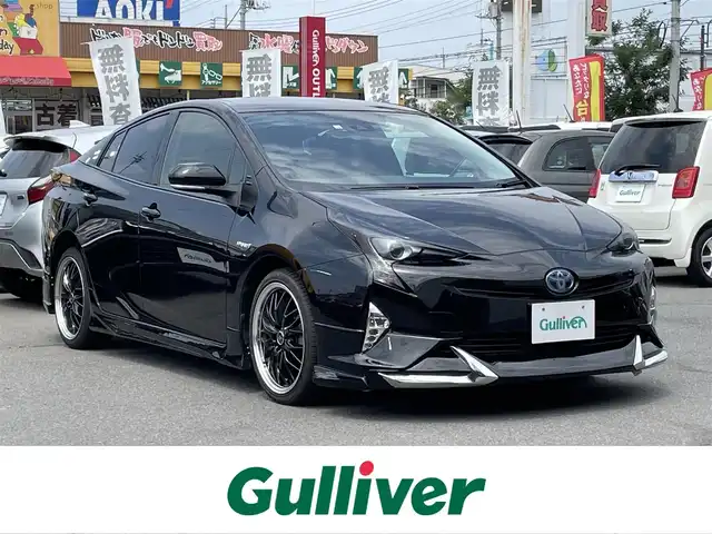 トヨタ プリウス S 群馬県 2016(平28)年 6.9万km 黒 純正ＳＤナビ/Ｂｌｕｅｔｏｏｔｈ/ワンセグＴＶ/ＣＤ/ＡＭＦＭ/バックカメラ/ＥＴＣ/オートライト/レーンキープアシスト/衝突軽減ブレーキ/レーダークルーズコントロール/社外エアロ/社外アルミホイール/革調シートカバー