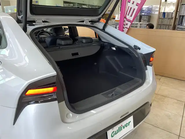 トヨタ プリウス Z 東京都 2023(令5)年 1.1万km プラチナホワイトパールマイカ ワンオーナー/メーカーナビ/（Bluetooth/フルセグ/USB/Miracast）/全方位カメラ/クリアランスソナー/ガラスルーフ/ブラックレザーシート/・前席シートヒーター/エアーシート/・運転席メモリーシート/純正デジタルインナーミラー/・F/Rドラレコ機能付き/レーダークルーズ/LDA/BSM/プロアクティブドライビングアシスト/RCTA/プリクラッシュセーフティ/アドバンストパーキング/パワーバックドア/革巻きステアリング/ステアリングヒーター/オートハイビーム/ライトレベライザー/オートライト/LEDライト/リアフォグライト/スマートキー/プッシュスタート/スペアキー/電動パーキング/オートホールド/ETC2.0/リアプライバシーガラス/ISOFIX/ワイヤレス充電/純正19インチアルミホイール/電動格納ウィンカーミラー/フロアマット/AC100V/オートエアコン/W+サイドSRS&ABS/横滑防止装置/新車時保証書/取扱説明書/ディーラー記録簿/（R6.3/R7.3）