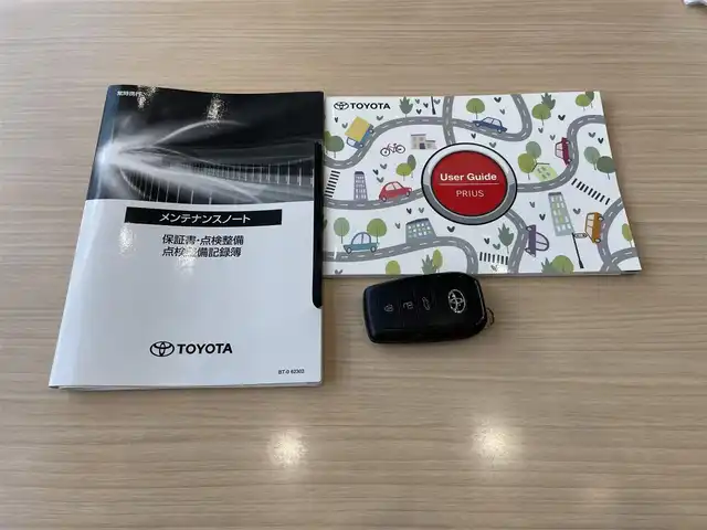 トヨタ プリウス Z 東京都 2023(令5)年 1.1万km プラチナホワイトパールマイカ ワンオーナー/メーカーナビ/（Bluetooth/フルセグ/USB/Miracast）/全方位カメラ/クリアランスソナー/ガラスルーフ/ブラックレザーシート/・前席シートヒーター/エアーシート/・運転席メモリーシート/純正デジタルインナーミラー/・F/Rドラレコ機能付き/レーダークルーズ/LDA/BSM/プロアクティブドライビングアシスト/RCTA/プリクラッシュセーフティ/アドバンストパーキング/パワーバックドア/革巻きステアリング/ステアリングヒーター/オートハイビーム/ライトレベライザー/オートライト/LEDライト/リアフォグライト/スマートキー/プッシュスタート/スペアキー/電動パーキング/オートホールド/ETC2.0/リアプライバシーガラス/ISOFIX/ワイヤレス充電/純正19インチアルミホイール/電動格納ウィンカーミラー/フロアマット/AC100V/オートエアコン/W+サイドSRS&ABS/横滑防止装置/新車時保証書/取扱説明書/ディーラー記録簿/（R6.3/R7.3）