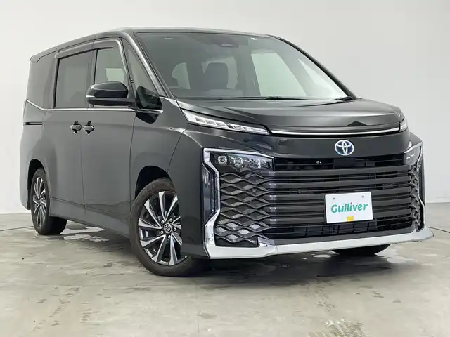 トヨタ ヴォクシー ハイブリッド S－Z 新潟県 2023(令5)年 1.4万km グリッターブラックガラスフレーク 10.5インチ純正メモリナビ/　フルセグTV/Bluetooth/CD/DVD/USB/レーダークルーズコントロール/衝突被害軽減ブレーキ/レーンキープアシスト/前後コーナーセンサー/両側パワースライドドア/ハーフレザーシート/前席シートヒーター/バックモニター/ビルトインETC/横滑り防止装置/LEDヘッドライト/オートマチックハイビーム/オートライト/ユニバーサルステップ/レザーステアリング/ステアリングスイッチ/禁煙車