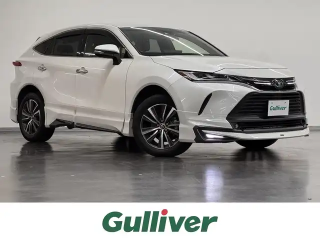 トヨタ ハリアー ハイブリッド G 三重県 2021(令3)年 3.5万km ホワイトパールクリスタルシャイン ハイブリッド/FF/MTモード付フロアCVT/純正 8インチ ディスプレイオーディオ/（AM/FM/Bluetooth/USB/iPod/CarPlay/AndroidAuto/Miracast/AUX）/バックガイドモニター/モデリスタエアロ（F/S/R下）/ドライブレコーダー 前後（デジタルミラー内蔵＋後付け）/ETC2.0/Toyota Safety Sense/●プリクラッシュセーフティ/●レーントレーシングアシスト/●レーダークルコン/●アダプティブハイビームシステム/●ロードサインアシスト/・先行車発進告知機能/・パーキングサポートブレーキ（前後静止物）/など/装備/・【OP】デジタルインナーミラー（前後録画機能付）/・パワーバックドア/・ハーフレザーシート/・パワーシート（D8way（2wayランバーサポート付））/・電動チルト・テレスコピックステアリング/・左右独立オートエアコン（ダイヤル型）/・オートワイパー/・電子パーキングブレーキ＆ブレーキホールド/・プッシュスタート/・純正18inAW/・保/・スマートキーx2/など