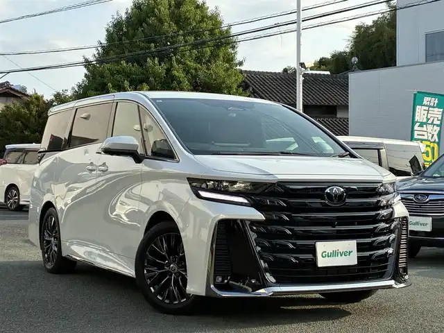 トヨタ ヴェルファイア ハイブリット Z プレミア 熊本県 2024(令6)年 0.5万km プラチナホワイトパールマイカ ワンオーナー/左右独立ムーンルーフ/トヨタチームメイト/ユニバーサルステップ/純正メーカーナビ/【フルセグTV/Bluetooth】/アランドビューモニター/デジタルインナーミラー/両側パワースライドドア/レーダークルーズコントロール/衝突被害軽減システム/ブラインドスポットモニター/パーキングサポートブレーキ/リアカメラディテクション安心降車アシスト/クリアランスソナー/レーンキープアシスト/レーンチェンジアシスト/ロードサインアシスト/プロアクティブドライビングアシスト/フロントクロストラフィックアラート/リアクロストラフィックアラート/後方車両接近装置/純正19インチAW/オートライト/LEDヘッドライト/茶レザーシート/パワーシート（メモリ付き）/シートヒーター/エアシート/後部座席オットマン/キャプテンシート/ステアリングヒーター/電動リアゲート/ビルトインETC/AC100V/USB/保証書