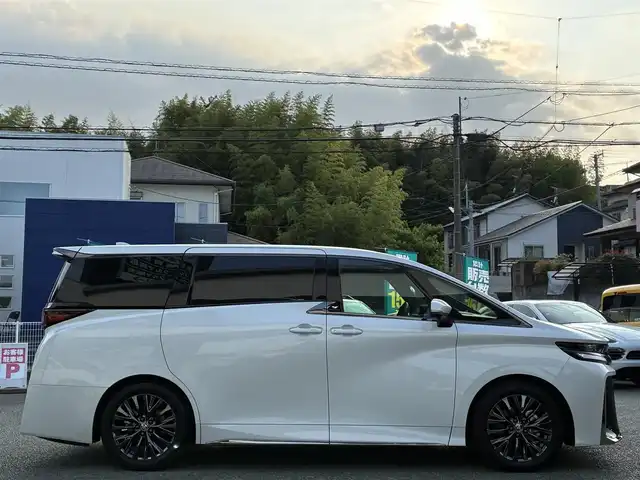 トヨタ ヴェルファイア ハイブリット Z プレミア 熊本県 2024(令6)年 0.5万km プラチナホワイトパールマイカ ワンオーナー/左右独立ムーンルーフ/トヨタチームメイト/ユニバーサルステップ/純正メーカーナビ/【フルセグTV/Bluetooth】/アランドビューモニター/デジタルインナーミラー/両側パワースライドドア/レーダークルーズコントロール/衝突被害軽減システム/ブラインドスポットモニター/パーキングサポートブレーキ/リアカメラディテクション安心降車アシスト/クリアランスソナー/レーンキープアシスト/レーンチェンジアシスト/ロードサインアシスト/プロアクティブドライビングアシスト/フロントクロストラフィックアラート/リアクロストラフィックアラート/後方車両接近装置/純正19インチAW/オートライト/LEDヘッドライト/茶レザーシート/パワーシート（メモリ付き）/シートヒーター/エアシート/後部座席オットマン/キャプテンシート/ステアリングヒーター/電動リアゲート/ビルトインETC/AC100V/USB/保証書