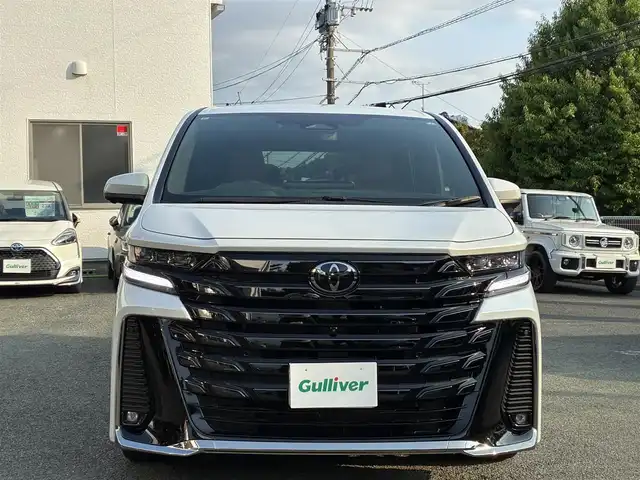 トヨタ ヴェルファイア ハイブリット Z プレミア 熊本県 2024(令6)年 0.5万km プラチナホワイトパールマイカ ワンオーナー/左右独立ムーンルーフ/トヨタチームメイト/ユニバーサルステップ/純正メーカーナビ/【フルセグTV/Bluetooth】/アランドビューモニター/デジタルインナーミラー/両側パワースライドドア/レーダークルーズコントロール/衝突被害軽減システム/ブラインドスポットモニター/パーキングサポートブレーキ/リアカメラディテクション安心降車アシスト/クリアランスソナー/レーンキープアシスト/レーンチェンジアシスト/ロードサインアシスト/プロアクティブドライビングアシスト/フロントクロストラフィックアラート/リアクロストラフィックアラート/後方車両接近装置/純正19インチAW/オートライト/LEDヘッドライト/茶レザーシート/パワーシート（メモリ付き）/シートヒーター/エアシート/後部座席オットマン/キャプテンシート/ステアリングヒーター/電動リアゲート/ビルトインETC/AC100V/USB/保証書