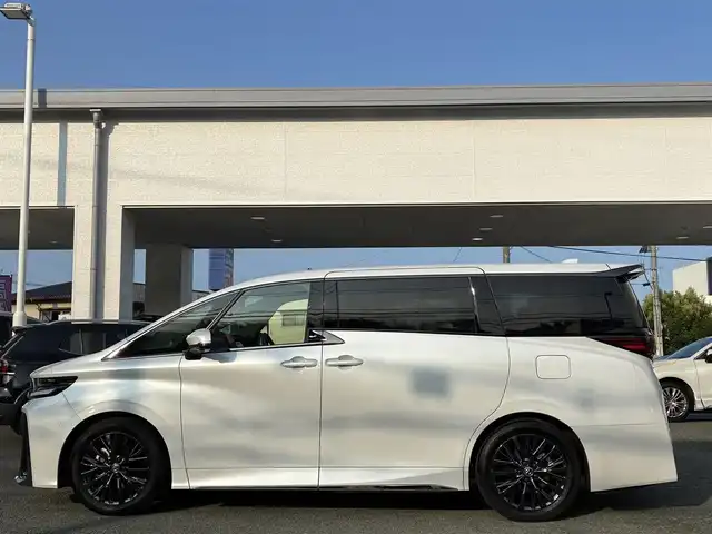 トヨタ ヴェルファイア ハイブリット Z プレミア 熊本県 2024(令6)年 0.5万km プラチナホワイトパールマイカ ワンオーナー/左右独立ムーンルーフ/トヨタチームメイト/ユニバーサルステップ/純正メーカーナビ/【フルセグTV/Bluetooth】/アランドビューモニター/デジタルインナーミラー/両側パワースライドドア/レーダークルーズコントロール/衝突被害軽減システム/ブラインドスポットモニター/パーキングサポートブレーキ/リアカメラディテクション安心降車アシスト/クリアランスソナー/レーンキープアシスト/レーンチェンジアシスト/ロードサインアシスト/プロアクティブドライビングアシスト/フロントクロストラフィックアラート/リアクロストラフィックアラート/後方車両接近装置/純正19インチAW/オートライト/LEDヘッドライト/茶レザーシート/パワーシート（メモリ付き）/シートヒーター/エアシート/後部座席オットマン/キャプテンシート/ステアリングヒーター/電動リアゲート/ビルトインETC/AC100V/USB/保証書
