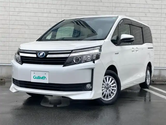 トヨタ ヴォクシー ハイブリッド V 静岡県 2014(平26)年 7.5万km ホワイトパールクリスタルシャイン 社外メモリーナビ(AVIC-RW710)/　AM FM CD DVD Bluetooth SD/ビルトインETC/LEDオートヘッドランプ/シートヒーター(前席)/両側パワースライドドア/クルーズコントロール/革巻きステアリング/ステアリングスイッチ/スマートキー＆プッシュスタート/純正15インチアルミホイール/リアロールサンシェード/フルセグTV/バックモニター/前後方ドライブレコーダー