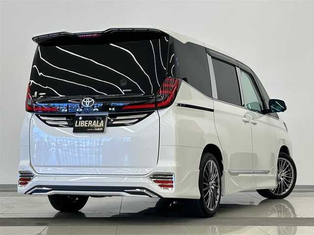 トヨタ ノア S－Z 岡山県 2025(令7)年 0.6万km ホワイトパールクリスタルシャイン トヨタ純正10.5インチナビ/アラウンドビューモニター/HDMI/USB/Bluetooth/アップルカープレイ/リアフリップダウンモニター/自動ブレーキ/LKA/BSA/ACC/ブレーキオートホールド/PTG/モデリスタフルエアロ/イルミルーフスポイラー/コーナーセンサー/社外18インチアルミ/社外フロアマット/ドアバイザー/デジタルインナーミラー/HUD/ドラレコ/CD/DVDプレイヤー/ベッドキット/釣り竿ホルダー