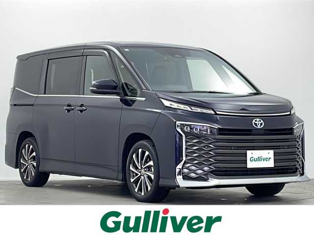 トヨタ ヴォクシー ハイブリッド S－Z 大阪府 2022(令4)年 1.6万km スパークリングブラックパールクリスタルシャイン 純正10.5インチディスプレイオーディオナビ/【フルセグTV/Bluetooth/HDMI/FM/AM】/快適利便パッケージ(High)/・両側ハンズフリーパワースライドドア/・後席シートヒーター/・後席オットマン/・パワーバックドア/・nanoe/プロジェクター式三眼LEDヘッドライト/ユニバーサルステップ/100V電源/バックカメラ/トヨタセーフティセンス/・プリクラッシュセーフティー/・オートマチックハイビーム/・レーントレーシングアシスト/・レーンディパーチャーアラート/・レーダークルーズコントロール/・パーキングサポートブレーキ/・ロードサインアシスト/・後退速度抑制/前後コーナーセンサー/ハーフレザーシート/前後シートヒーター/ステアリングヒーター/後席サンシェード/オートリトラミラー/オートホールド/純正17インチAW/ビルトインETC2.0/WAC/スマートキー/プッシュスタート