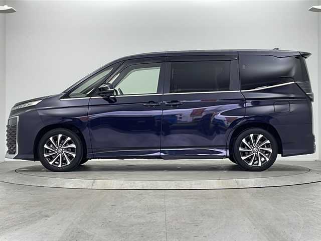 トヨタ ヴォクシー ハイブリッド S－Z 大阪府 2022(令4)年 1.6万km スパークリングブラックパールクリスタルシャイン 純正10.5インチディスプレイオーディオナビ/【フルセグTV/Bluetooth/HDMI/FM/AM】/快適利便パッケージ(High)/・両側ハンズフリーパワースライドドア/・後席シートヒーター/・後席オットマン/・パワーバックドア/・nanoe/プロジェクター式三眼LEDヘッドライト/ユニバーサルステップ/100V電源/バックカメラ/トヨタセーフティセンス/・プリクラッシュセーフティー/・オートマチックハイビーム/・レーントレーシングアシスト/・レーンディパーチャーアラート/・レーダークルーズコントロール/・パーキングサポートブレーキ/・ロードサインアシスト/・後退速度抑制/前後コーナーセンサー/ハーフレザーシート/前後シートヒーター/ステアリングヒーター/後席サンシェード/オートリトラミラー/オートホールド/純正17インチAW/ビルトインETC2.0/WAC/スマートキー/プッシュスタート