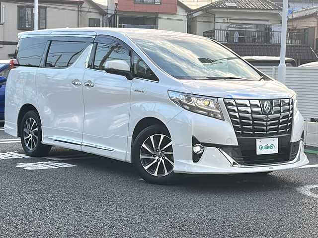 トヨタ アルファードハイブリット G Fパッケージ 東京都 2015(平27)年 7万km ホワイトパールクリスタルシャイン 純正メモリナビ/　CD/DVD/BT/フルセグテレビ/バックカメラ/全方位カメラ/フリップダウンモニター/ウィンカーミラー/オットマン/キャプテンシート/クルーズコントロール/ドアバイザー/プッシュスタート/両側パワースライドドア/パワーバックドア/ビルトインETC/LEDヘッドライト/レザーシート/D/Nシートヒーター/パワーシート/置くだけ充電/前後コーナーセンサー/JBLサウンド/モデリスタエアロ/ハンドルヒーター