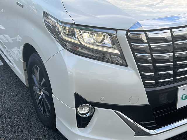トヨタ アルファードハイブリット G Fパッケージ 東京都 2015(平27)年 7万km ホワイトパールクリスタルシャイン 純正メモリナビ/　CD/DVD/BT/フルセグテレビ/バックカメラ/全方位カメラ/フリップダウンモニター/ウィンカーミラー/オットマン/キャプテンシート/クルーズコントロール/ドアバイザー/プッシュスタート/両側パワースライドドア/パワーバックドア/ビルトインETC/LEDヘッドライト/レザーシート/D/Nシートヒーター/パワーシート/置くだけ充電/前後コーナーセンサー/JBLサウンド/モデリスタエアロ/ハンドルヒーター