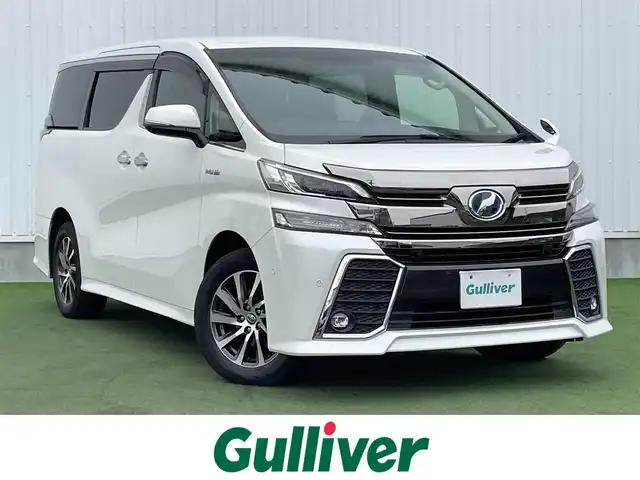 トヨタ ヴェルファイア ハイブリット ZR 香川県 2015(平27)年 8.9万km プレシャスホワイトパール 登録時走行距離：88289km/4WD/純正9インチナビ/→AM/FM/フルセグTV/Bluetooth/→CD/DVD再生/→HDMI入力/JBLプレミアムサウンドシステム/バックカメラ/クルーズコントロール/シートメモリー付きパワーシート/ハーフレザーシート/オットマン/キャプテンシート/両側パワースライドドア/パワーバックドア/LEDオートライト/フォグランプ/オートハイビーム/トヨタセーフティセンス/→プリクラッシュセーフティ/→レーンディパーチャーアラート/→クリアランスソナー/プッシュスタート/スマートキー