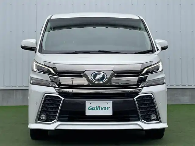 トヨタ ヴェルファイア ハイブリット ZR 香川県 2015(平27)年 8.9万km プレシャスホワイトパール 登録時走行距離：88289km/4WD/純正9インチナビ/→AM/FM/フルセグTV/Bluetooth/→CD/DVD再生/→HDMI入力/JBLプレミアムサウンドシステム/バックカメラ/クルーズコントロール/シートメモリー付きパワーシート/ハーフレザーシート/オットマン/キャプテンシート/両側パワースライドドア/パワーバックドア/LEDオートライト/フォグランプ/オートハイビーム/トヨタセーフティセンス/→プリクラッシュセーフティ/→レーンディパーチャーアラート/→クリアランスソナー/プッシュスタート/スマートキー