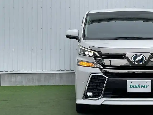 トヨタ ヴェルファイア ハイブリット ZR 香川県 2015(平27)年 8.9万km プレシャスホワイトパール 登録時走行距離：88289km/4WD/純正9インチナビ/→AM/FM/フルセグTV/Bluetooth/→CD/DVD再生/→HDMI入力/JBLプレミアムサウンドシステム/バックカメラ/クルーズコントロール/シートメモリー付きパワーシート/ハーフレザーシート/オットマン/キャプテンシート/両側パワースライドドア/パワーバックドア/LEDオートライト/フォグランプ/オートハイビーム/トヨタセーフティセンス/→プリクラッシュセーフティ/→レーンディパーチャーアラート/→クリアランスソナー/プッシュスタート/スマートキー