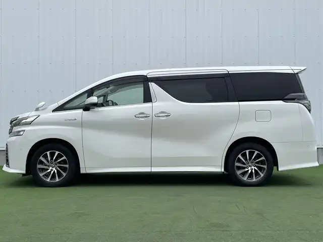トヨタ ヴェルファイア ハイブリット ZR 香川県 2015(平27)年 8.9万km プレシャスホワイトパール 登録時走行距離：88289km/4WD/純正9インチナビ/→AM/FM/フルセグTV/Bluetooth/→CD/DVD再生/→HDMI入力/JBLプレミアムサウンドシステム/バックカメラ/クルーズコントロール/シートメモリー付きパワーシート/ハーフレザーシート/オットマン/キャプテンシート/両側パワースライドドア/パワーバックドア/LEDオートライト/フォグランプ/オートハイビーム/トヨタセーフティセンス/→プリクラッシュセーフティ/→レーンディパーチャーアラート/→クリアランスソナー/プッシュスタート/スマートキー