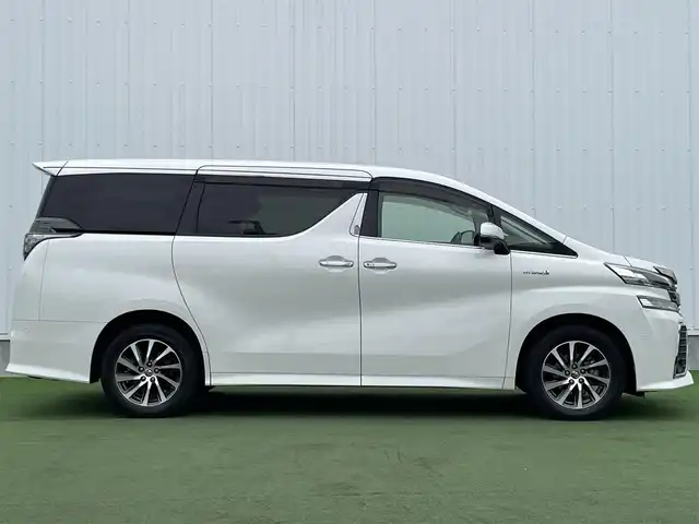 トヨタ ヴェルファイア ハイブリット ZR 香川県 2015(平27)年 8.9万km プレシャスホワイトパール 登録時走行距離：88289km/4WD/純正9インチナビ/→AM/FM/フルセグTV/Bluetooth/→CD/DVD再生/→HDMI入力/JBLプレミアムサウンドシステム/バックカメラ/クルーズコントロール/シートメモリー付きパワーシート/ハーフレザーシート/オットマン/キャプテンシート/両側パワースライドドア/パワーバックドア/LEDオートライト/フォグランプ/オートハイビーム/トヨタセーフティセンス/→プリクラッシュセーフティ/→レーンディパーチャーアラート/→クリアランスソナー/プッシュスタート/スマートキー