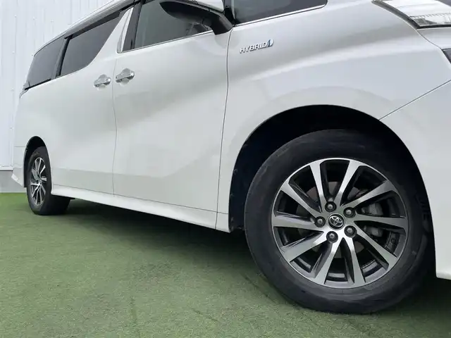 トヨタ ヴェルファイア ハイブリット ZR 香川県 2015(平27)年 8.9万km プレシャスホワイトパール 登録時走行距離：88289km/4WD/純正9インチナビ/→AM/FM/フルセグTV/Bluetooth/→CD/DVD再生/→HDMI入力/JBLプレミアムサウンドシステム/バックカメラ/クルーズコントロール/シートメモリー付きパワーシート/ハーフレザーシート/オットマン/キャプテンシート/両側パワースライドドア/パワーバックドア/LEDオートライト/フォグランプ/オートハイビーム/トヨタセーフティセンス/→プリクラッシュセーフティ/→レーンディパーチャーアラート/→クリアランスソナー/プッシュスタート/スマートキー