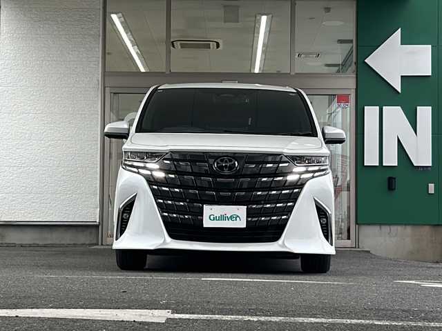 トヨタ アルファードハイブリット Z 愛知県 2024(令6)年 1.4万km プラチナホワイトパールマイカ 禁煙車/法人ワンオーナー/純正メーカーナビ、TV/パノラミックビューモニター/レザーシート/独立サンルーフ/両側パワースライドドア/トヨタチームメイト/自動駐車/ユニバーサルステップ/ヘッドアップディスプレイ/ブラインドスポットモニター/フリップダウンモニター/デジタルインナーミラー/アダプティプクルーズコントロール/レーンキープアシスト/パドルシフト/置くだけ充電/HDMI/前後コーナーセンサー/クリアランスソナー/Bluetooth/Miracast/ステアリングリモコン/ハンドルヒーター/シートヒーター（セカンドシートまで）/エアシート（セカンドシートまで）/パワーシート/メモリーシート/オットマン/後席サンシェード/AUTOHOLD/純正18アルミ/純正フロアマット/ドアバイザー/フォグランプ/LEDヘッドライト/AUTOライト/AUTOハイビーム/ETC/前後ドラレコ/スペアキー/取扱説明書/保証書