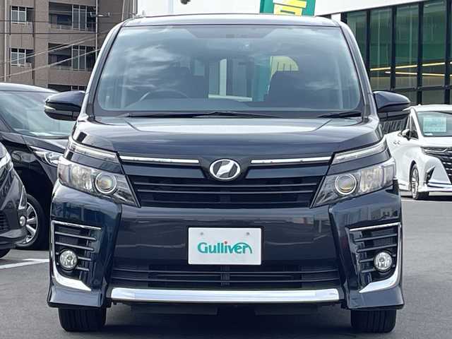 トヨタ ヴォクシー ZS 長野県 2014(平26)年 5.6万km ブラッキッシュアゲハガラスフレーク 禁煙車/純正ナビ【NSZT-W64】/（ＣＤ／ＤＶＤ／フルセグＴＶ／Ｂｌｕｅｔｏｏｔｈ）/バックカメラ/ビルトインＥＴＣ/社外フリップダウンモニター/両側パワースライドドア/前後ドライブレコーダー/革巻きステアリング/ステアリングスイッチ/LEDヘッドライト/フォグランプ/オートライト/スマートキー/Pスタート/電動格納ミラー/純正16インチAW/フロアマット/純正ドアバイザー