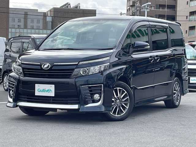 トヨタ ヴォクシー ZS 長野県 2014(平26)年 5.6万km ブラッキッシュアゲハガラスフレーク 禁煙車/純正ナビ【NSZT-W64】/（ＣＤ／ＤＶＤ／フルセグＴＶ／Ｂｌｕｅｔｏｏｔｈ）/バックカメラ/ビルトインＥＴＣ/社外フリップダウンモニター/両側パワースライドドア/前後ドライブレコーダー/革巻きステアリング/ステアリングスイッチ/LEDヘッドライト/フォグランプ/オートライト/スマートキー/Pスタート/電動格納ミラー/純正16インチAW/フロアマット/純正ドアバイザー