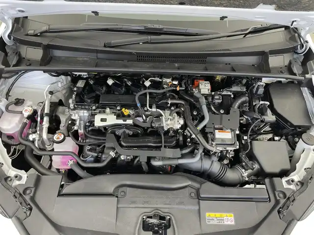 トヨタ プリウス Z 千葉県 2023(令5)年 1.3万km プラチナホワイトパールマイカ セーフティセンス（予防安全パッケージ）/・プリクラッシュセーフティ/・フロントクロストラフィックアラート/・レーントレーシングアシスト/・レーダークルーズコントロール/・ロードサインアシスト/・ドライバー異常時対応システム/・プロアクティブドライビングアシスト/・発進遅れ告知機能/・緊急時操舵支援/・レーンチェンジアシスト/・レーンディパーチャーアラート/・オートマチックハイビーム/12.3インチディスプレイオーディオ/・コネクティッドナビ対応 12.3インチHDディスプレイ/・地デジTV/・AM/FMラジオ/・USBタイプC入力/・Apple CarPlay / Android Auto/パノラマルーフ/純正19インチAW/メモリー付きパワーシート/LEDヘッドライト/AC100V/ETC2.0