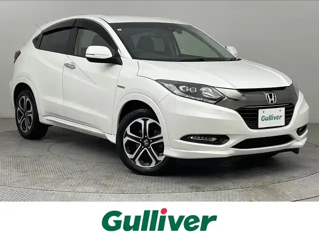 ホンダ ヴェゼル ハイブリッド 道央・札幌 2017(平29)年 6.7万km ホワイトオーキッドパール ・４WD/・寒冷地仕様/・純正SDナビゲーション/　CD/DVD/SD/BT/ワンセグ/USB/iPod/・社外前方録画ドライブレコーダー/・バックカメラ/・ビルトインETC/・ホンダセンシング/・衝突軽減ブレーキ/・レーンキープアシスト/・レーダークルーズコントロール/・先行車発進通知/・横滑り防止装置/・ハーフレザーシート/・前席シートヒーター/・LEDヘッドライト/・フロントフォグライト/・オートライト/・ステアリングスイッチ/・スマートキー/・プッシュスタート/・パドルシフト/・純正フロアマット/・チップアップシート/・純正AW17インチ/・ドアバイザー