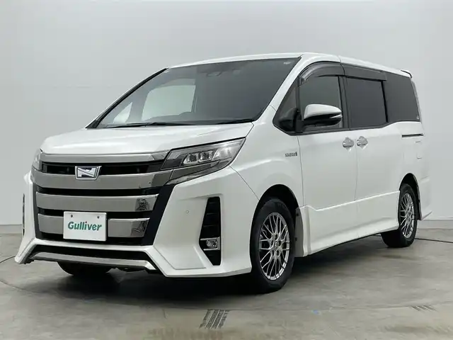 トヨタ ノア ハイブリッド Si ダブルバイビーⅡ 岡山県 2019(令1)年 6.2万km ホワイトパールクリスタルシャイン 純正9型ナビ（NSZT-Y68T）/【フルセグTV/CD/DVD/BT】/バックカメラ/純正12.1インチフリップダウンモニター/両側パワースライドドア/トヨタセーフティセンス/クルーズコントロール/ビルトインETC/ステアリングリモコン/ハーフレザーシート/D/Nシートヒーター/LEDオートライト/フォグランプ/スマートキー/プッシュスタート/フロアマット/純正ドアバイザー