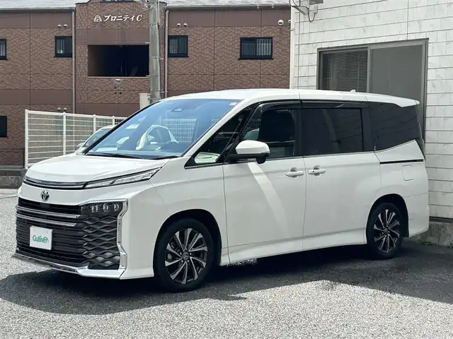 トヨタ ヴォクシー ハイブリッド S－Z 福岡県 2022(令4)年 3.8万km ホワイトパールクリスタルシャイン ワンオーナー/快適利便パッケージ/・nanoeXエアコン/・パワーバックドア/・後部座席オットマン、シートヒーター/・ステアリングヒーター/純正10.5インチコネクティッドナビ/（AM/FM/CD/DVD/Miracast/Bluetooth/フルセグTV）/バックカメラ/トヨタセーフティセンス/・オートマチックハイビーム/・プリクラッシュセーフティ/・レーントレーシングアシスト/・レーンチェンジアシスト/・レーンディバーチャーアラート/・プロアクティブドライビングアシスト/・発進遅れ告知機能/・ロードサインアシスト/・レーダークルーズコントロール/・ドライバー異常時対応システム/・ドライバーモニター/・フロントクロストラフィックアラート/・リアクロストラフィックアラート/クリアランスソナー/コーナーセンサー/ブラインドスポットモニター/オートライト/横滑り防止装置/純正17インチAW/黒色ハーフレザーシート/シートヒーター（D/N）/KEENWOOD製前後ドライブレコーダー【DRV-MR740】/後部座席サンシェード/純正フロアマット/100V電源ソケット×1/スペアキー×1/保証書/取扱説明書/ナビ取扱説明書