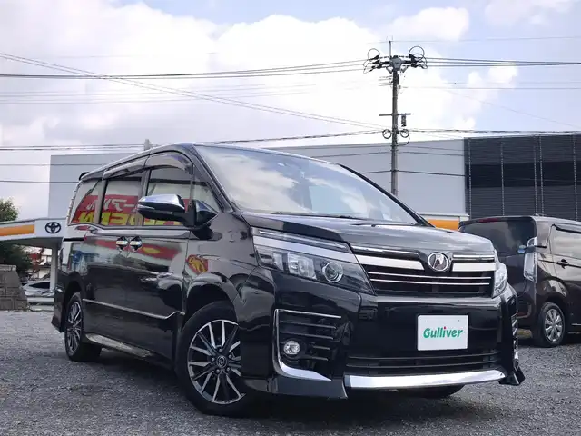 トヨタ ヴォクシー ZS 煌Ⅱ 熊本県 2016(平28)年 10万km ブラック 純正9インチナビ（NSZT-Y66T）/【フルセグTV/Bluetooth/CD/DVD/HDMI】/バックカメラ/純正12.1インチフリップダウンモニター/両側パワースライドドア/衝突被害軽減システム/車線逸脱警報/オートLEDヘッドライト/プッシュスタート/スマートキー/純正16インチAW/ドライブレコーダー/ETC/ウインカーミラー