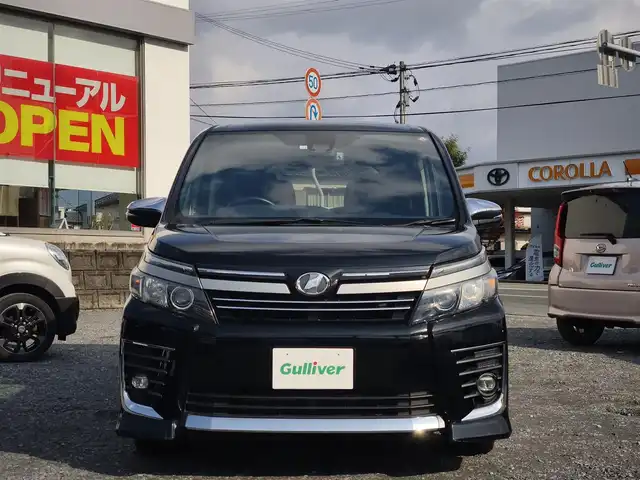 トヨタ ヴォクシー ZS 煌Ⅱ 熊本県 2016(平28)年 10万km ブラック 純正9インチナビ（NSZT-Y66T）/【フルセグTV/Bluetooth/CD/DVD/HDMI】/バックカメラ/純正12.1インチフリップダウンモニター/両側パワースライドドア/衝突被害軽減システム/車線逸脱警報/オートLEDヘッドライト/プッシュスタート/スマートキー/純正16インチAW/ドライブレコーダー/ETC/ウインカーミラー