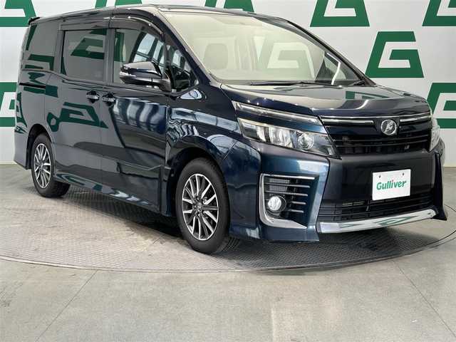 トヨタ ヴォクシー ZS 鹿児島県 2014(平26)年 7.5万km ブラッキッシュアゲハガラスフレーク ワンオーナー/片側パワースライドドア/アイドリングストップ/純正7インチSDナビ【NSCP-W62】/（CD/DVD/ワンセグ/Bluetooth/SD）/ビルトインETC/バックカメラ/革巻きステアリング/ステアリングリモコン/純正LEDヘッドライト/フロントフォグランプ/オートライト/スペアタイヤ1本/純正フロアマット/純正ドアバイザー/純正16インチアルミ/保証書&取扱説明書