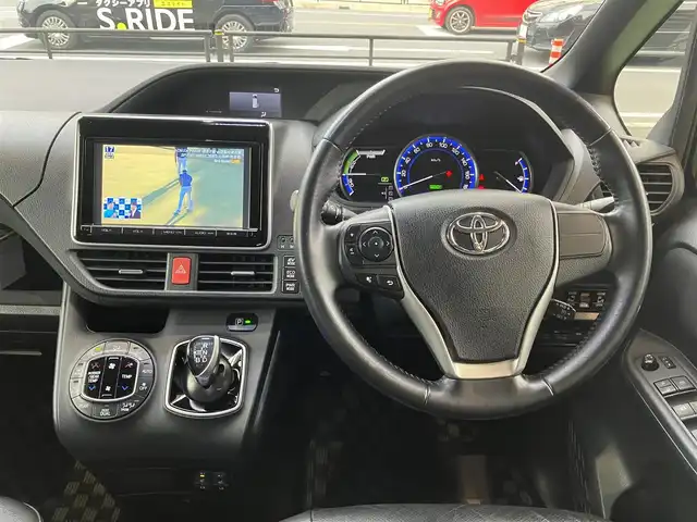 トヨタ ヴォクシー ハイブリッド V 神奈川県 2015(平27)年 10.9万km ブラック 新車保証書/取扱説明書/スマートキー/スペアキー/純正ナビ・フルセグTV/CD・DVDビデオ・Bluetooth/バックカメラ/フリップダウンモニター/ビルトインETC/置くだけ充電/両側パワースライドドア/クルーズコントロール/前席シートヒーター/LEDヘッドライト/モデリスタエアロ/リアスポイラー/純正15インチアルミホイール