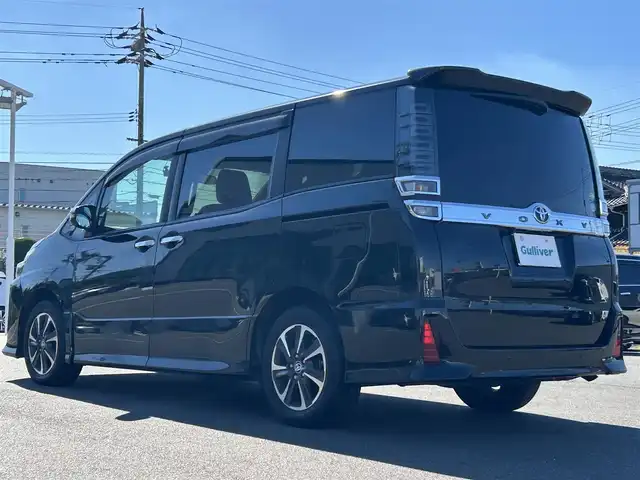 トヨタ ヴォクシー ZS 煌Ⅱ 岡山県 2019(令1)年 2.1万km イナズマスパーキングブラックガラスフレーク 登録時走行距離20163km/純正10インチナビ/フルセグTV（AM/FM/CD/DVD/Bluetooth）/ビルトインETC/バックカメラ/両側パワースライドドア/前後ドライブレコーダー/アイドリングストップ/トヨタセーフティセンス/・オートマチックハイビーム/・レーンディパーチャーアラート/・プリクラッシュセーフティ/クルーズコントロール/横滑り防止装置/USB入力端子/純正16インチAW/社外フロアマット/プッシュスタート/スマートキー