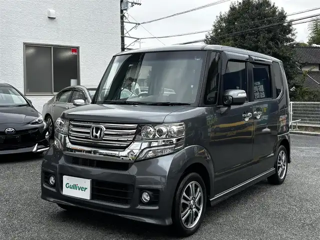 ホンダ Ｎ ＢＯＸ カスタム G Lパッケージ 熊本県 2013(平25)年 13.3万km ポリッシュドメタルメタリック 純正ナビ（VXM-128VS）/【ワンセグTV/CD/DVD】/バックカメラ/片側パワースライドドア/純正14インチAW/アイドリングストップ/横滑り防止/プッシュスタート/スマートキー/スペアキー/ウインカーミラー/純正フロアマット/ドアバイザー/取扱説明書