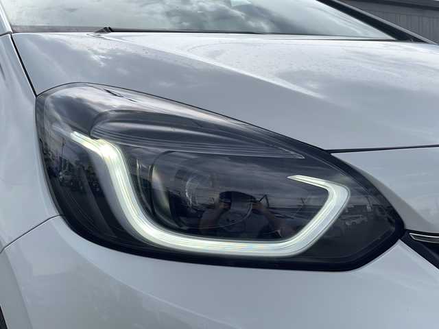ホンダ フィット e:HEVホーム 道北・旭川 2023(令5)年 1.4万km プラチナホワイトパール ・純正ナビ/BT/DTV/DVD/CD/USB/・寒冷地仕様/・４WD/・前席シートヒーター/・バックカメラ/・社外前後ドライブレコーダー/・ステアリングリモコン/・電動パーキングブレーキ/・オートブレーキホールド/・ホンダセンシング/衝突軽減ブレーキ/踏み間違い衝突軽減システム/急アクセル抑制機能/路外逸脱抑制機能/歩行者事故低減ステアリング/先行車発進お知らせ機能/標識認識機能/レーダークルーズコントロール/・電動格納ミラー/・純正ゴムフロアマット/・純正カーペット/・ミラーヒーター/・ワイパーデアイサー/・保証書/・取説/・ナビ説/・スペアキー