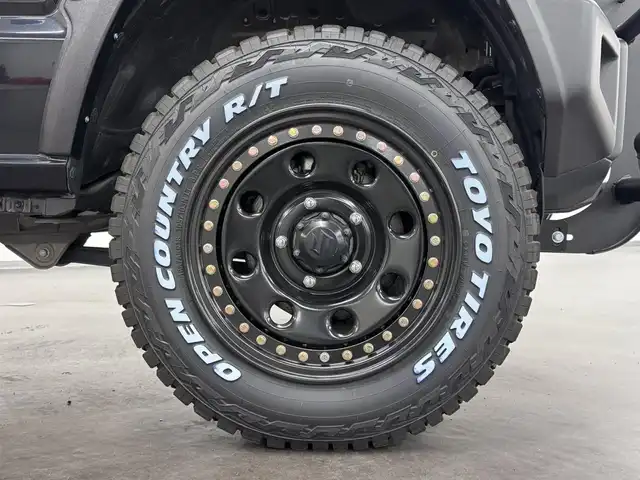スズキ ジムニー XC 三重県 2023(令5)年 0.1千km ブルーイッシュブラックパール3 届出済未使用車（商品化登録時走行距離19km）/ガソリン・ターボ/パートタイム4WD/フロア4AT/カスタムパーツ/・METAL ROCK 16inビートリングAW/・大型グリルガード/・GIGEAR LEDフォグライト/・GIGEAR リアラダー/・GIGEAR ブラウンキルティングレザーシートカバー/・オーバーフェンダー/・GIGEAR 1.5インチリフトアップキット/・トーヨー・オープンカントリーR/T 185/85R16/9インチ ディスプレイオーディオ/（FM/AM/Bluetooth/USB/AUX/AppleCarPlay/AndroidAuto?）/バックカメラ/安全/・デュアルセンサーブレーキサポート/・車線逸脱警報機能/・ふらつき警報機能/・標識認識機能/・ハイビームアシスト/・トラクションコントロールシステム/・ヒルディセントコントロール/など/装備/・クルーズコントロール/・シートヒーター（D/N）/・オートエアコン/・ステアリングスイッチ/・オートライト/・LEDヘッドランプ/・フロントフォグランプ/・プッシュスタート/・電動格納ドアミラー/・背面スペアタイヤ/・保/取/ナビ取/・スマートキーx1/など