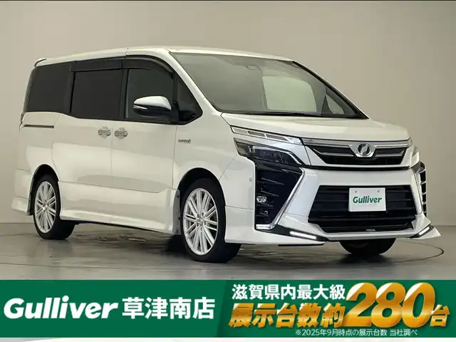トヨタ ヴォクシー ハイブリッド ZS 煌 滋賀県 2018(平30)年 8.7万km ホワイトパールクリスタルシャイン 純正9インチナビ/CD/DVD/USB/HDMI/Bluetooth/フルセグテレビ/バックカメラ/TRDエアロ/セーフティセンス/・プリクラッシュセーフティ/・レーンディパーチャーアラート/・オートマチックハイビーム/・先行車発進告知機能/クルーズコントロール/両側パワースライドドア/LEDヘッドライト/オートライト/ビルトインETC/デジタルインナーミラー/D/N席シートヒーター /プッシュスタート /スマートキー/スペアキー/純正フロアマット