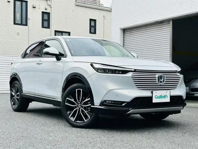 ホンダ ヴェゼル ハイブリッド e:HEV Z 神奈川県 2023(令5)年 1.4万km プレミアムサンライトホワイトパール ワンオーナー/純正メモリナビ/・DTV/Bluetooth/バックカメラ/全方位モニタ/前後ドライブレコーダー/ハーフレザーシート/前席シートヒーター/ステアリングヒーター/デジタルインナーミラー/Honda SENSING/・衝突軽減ブレーキ/・踏み間違い衝突軽減システム/・路外逸脱抑制機能/・先行車発進告知機能/・オートハイビーム/・ブラインドスポットインフォメーション/・アダプティブクルーズコントロール/・車線維持支援システム/・パーキングセンサーシステム/横滑り防止機能/盗難防止機能/純正18インチアルミホイール/純正LEDヘッドライト/フォグランプ/純正フロアマット/革巻きステアリング/ビルトインETC2.0/プッシュエンジンスタート/スマートキー×1/取扱説明書/新車時保証書