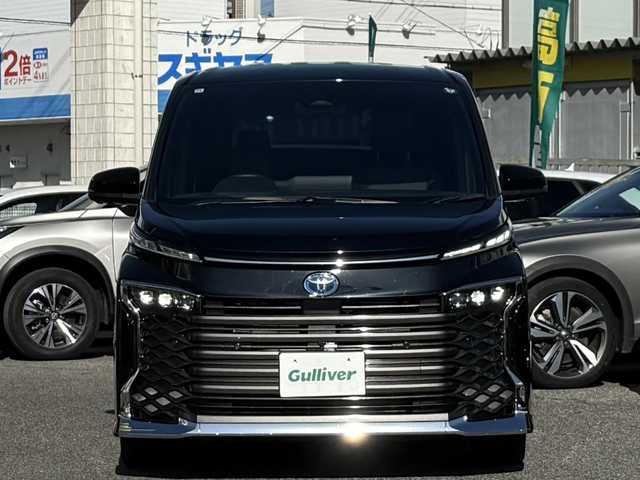 トヨタ ヴォクシー ハイブリッド S－Z 愛知県 2024(令6)年 1.6万km アティチュードブラックマイカ /ワンオーナー車//D記録簿R6-R7//10.5インチディスプレイオーディオ//AM/FM/TV（フルセグ）＋CD・DVDデッキ//BT/USB/Miracast//快適利便パッケージ//ハンズフリーデュアルパワースライドドア//パワーバックドア//1列目2列目シートヒーター//2列目オットマン//2列目角度調整付きアームレスト//ドライビングサポートパッケージ//カラーヘッドアップディスプレイ//デジタルインナーミラー//純正13.2インチ有機EL後席モニター//ETC2.0//レーダークルーズコントロール//ブラインドスポットモニター//レーンディパーチャーアラート//プリクラッシュセーフティー//プロアクティブドライビングシステム//クリアランスソナー//リヤクロストラフィックアラート//リヤカメラディテクション//パーキングサポートブレーキ//安心降車アシスト//ロードサインアシスト//レーンチェンジアシスト//フロントクロストラフィックアラート//アドバンストパーク//パノラミックビューモニター//バックカメラ//オートLEDヘッドライト//オートハイビーム//オートブレーキホールド//電動パーキングブレーキ//ステアリングスイッチ//ステアリングヒーター//AC100V//保証書//取説
