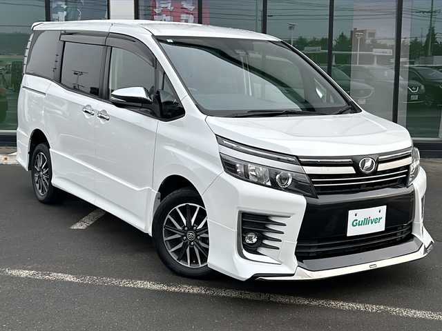 トヨタ ヴォクシー ZS 煌Ⅱ 道東・釧路十勝 2017(平29)年 11.5万km ホワイトパールクリスタルシャイン ・4WD/・純正9インチメモリナビ/（CD/DVD/BT/SD/USB）/・両側パワースライドドア/・バックカメラ/・純正12.9インチフリップダウンモニター/・モデリスタリップスポイラー/・ETC/・ドアバイザー/・アイドリングストップ/・LEDヘッドライト/・フォグランプ/・オートライト/・オートマチックハイビーム/・プッシュスタート/・スマートキー/・純正アルミホイール