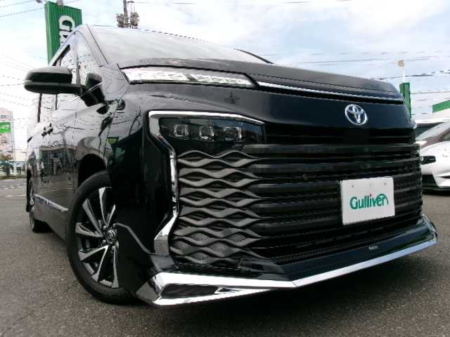 トヨタ ヴォクシー ハイブリッド S－Z 岡山県 2023(令5)年 3.5万km アティチュードブラックマイカ 【 Toyota Safety Sense 】/・LDA/・PCS/・RSA/・AHB/・PDA/PKSB/オートライト/レーダークルーズコントロール/モデリスタエアロ/ディスプレイオーディオプラス/車載メモリーナビ/14型有機ELフリップダウンモニター/バックカメラ/DVD再生可能/AppleCarPlay/AndroidAuto/Bluetooth/HDMI/AC100V/USB（前席・2ｎｄシート）/DVDデッキ/パワーバックドア/両側パワースライドドア/ハンズフリーデュアルパワースライドドア/ユニバーサルステップ/ハーフレザーシート/シートヒーター（D/N/2ｎｄシート）/純正ドライブレコーダー（フロント・リア）/2.0対応ビルトインETC/純正フロアマット/純正17AW/スマートキー2個